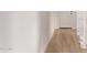 Bright hallway features sleek wood-look flooring and leads to a white door with modern black hardware at 2339 W Ponderosa Ln, Phoenix, AZ 85023