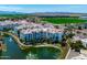 Wide aerial view of condos surrounded by lush landscaping, green fields and mountains in the distance at 2511 W Queen Creek Rd # 116, Chandler, AZ 85248