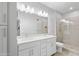 Bright bathroom featuring dual sinks, white cabinets, and a glass door shower at 2511 W Queen Creek Rd # 116, Chandler, AZ 85248