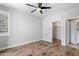 Cozy bedroom with hard wood flooring, a ceiling fan, and closet access at 2511 W Queen Creek Rd # 116, Chandler, AZ 85248