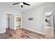 Spacious bedroom featuring hardwood flooring, a ceiling fan, and bathroom access at 2511 W Queen Creek Rd # 116, Chandler, AZ 85248