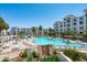 Large community pool surrounded by lounge chairs, tables, and manicured landscaping at 2511 W Queen Creek Rd # 116, Chandler, AZ 85248