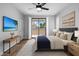 Beautiful main bedroom featuring balcony access, a ceiling fan, and a TV at 2511 W Queen Creek Rd # 116, Chandler, AZ 85248