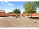 Gravel backyard featuring brick fence, mature trees, and an inviting fire pit area at 2738 E Silversmith Trl, San Tan Valley, AZ 85143