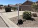 Landscaped front yard featuring a blank sign post, decorative gravel, green bushes, and a toolbox at 2738 E Silversmith Trl, San Tan Valley, AZ 85143