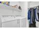 Functional laundry room with washer, dryer, shelves, and hanging storage at 2738 E Silversmith Trl, San Tan Valley, AZ 85143