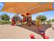 Community playground featuring modern structures and shade canopies at 2738 E Silversmith Trl, San Tan Valley, AZ 85143