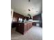 A large kitchen with an island with a granite countertop and cherry wood cabinets at 29474 W Columbus Ave, Buckeye, AZ 85396