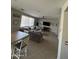 Open-concept living room with dining area, featuring tile floors, large sofa, and plenty of natural light at 29474 W Columbus Ave, Buckeye, AZ 85396