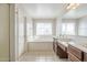 Bright bathroom with double sinks, large mirror, soaking tub, and separate toilet room at 29474 W Columbus Ave, Buckeye, AZ 85396