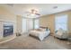 Spacious main bedroom featuring a cozy fireplace, ceiling fan and windows for natural light at 29474 W Columbus Ave, Buckeye, AZ 85396