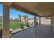 Inviting covered patio overlooking a spacious backyard with lush green lawn and mature palm trees at 30308 W Whitton Ave, Buckeye, AZ 85396