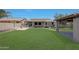 Well-manicured backyard with green lawn, outdoor kitchen, and covered area for relaxation and entertaining at 30308 W Whitton Ave, Buckeye, AZ 85396