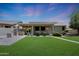 Well-maintained backyard with a built-in barbecue, covered patio, and manicured landscaping at 30308 W Whitton Ave, Buckeye, AZ 85396