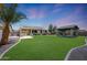 Expansive backyard showcases a covered patio, outdoor barbecue area, gazebo, and vibrant green lawn at 30308 W Whitton Ave, Buckeye, AZ 85396