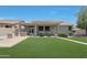 Expansive backyard featuring a built-in outdoor kitchen, covered patio, and lush green lawn at 30308 W Whitton Ave, Buckeye, AZ 85396