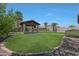 Large backyard featuring a covered entertainment area with a mounted TV, perfect for entertaining at 30308 W Whitton Ave, Buckeye, AZ 85396