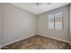 Empty bedroom featuring wood-look floors, a window, and a ceiling fan at 30308 W Whitton Ave, Buckeye, AZ 85396