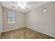 Empty bedroom featuring wood-look floors, a window, and a ceiling fan at 30308 W Whitton Ave, Buckeye, AZ 85396