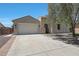 Charming home featuring a two-car garage and a welcoming front entry with a paved driveway at 30308 W Whitton Ave, Buckeye, AZ 85396
