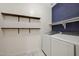This laundry room features blue tile and new Samsung white front loading washer and dryer at 30308 W Whitton Ave, Buckeye, AZ 85396