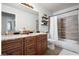 Bathroom with double sinks, granite counters, dark wood cabinets, and tiled shower at 3224 E Desert Cove Ave, Phoenix, AZ 85028