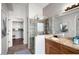 Bathroom showcasing a glass-enclosed shower, granite vanity, and a view into the walk-in closet at 3224 E Desert Cove Ave, Phoenix, AZ 85028