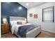 Cozy bedroom with a decorative blue accent wall, soft bedding, and a window with natural light at 3224 E Desert Cove Ave, Phoenix, AZ 85028