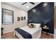 Stylish bedroom featuring a navy accent wall, ceiling fan, window, and hardwood floors at 3224 E Desert Cove Ave, Phoenix, AZ 85028
