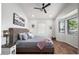 Bright main bedroom featuring hardwood floors, a ceiling fan, and natural light from the windows at 3224 E Desert Cove Ave, Phoenix, AZ 85028