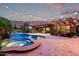 Expansive backyard with a pool, spa, lush landscaping, and an outdoor living area with a TV at 3460 E Lynx Pl, Chandler, AZ 85249
