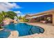 Spacious backyard featuring a pool with rock features, a play structure, and covered outdoor living spaces at 3460 E Lynx Pl, Chandler, AZ 85249