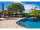 Resort-style backyard with a custom pool, spa, waterfall, outdoor kitchen, and ample seating areas at 3460 E Lynx Pl, Chandler, AZ 85249