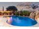 Gorgeous backyard with a custom pool, rock waterfall feature, outdoor kitchen, and lush landscaping at 3460 E Lynx Pl, Chandler, AZ 85249