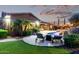 Beautiful backyard with a pool, lounge chairs, lush landscaping, and an outdoor seating area under string lights at 3460 E Lynx Pl, Chandler, AZ 85249