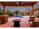 Inviting backyard featuring a pool with waterfall, a play structure, and a cozy seating area with a fire pit at 3460 E Lynx Pl, Chandler, AZ 85249