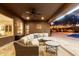 Backyard covered patio with sectional seating, outdoor lighting, and pool access for entertaining at 3460 E Lynx Pl, Chandler, AZ 85249