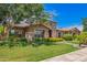 Charming home featuring stone accents, a manicured lawn, and lush landscaping, showcasing curb appeal and inviting ambiance at 3460 E Lynx Pl, Chandler, AZ 85249