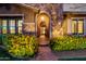 Inviting front exterior of home showcasing a stone facade and archway, complemented by vibrant yellow flowers and lush greenery at 3460 E Lynx Pl, Chandler, AZ 85249