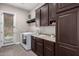 Laundry room featuring stainless steel appliances, ample cabinetry, and backyard access door at 3460 E Lynx Pl, Chandler, AZ 85249