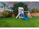 Backyard featuring playground with slide and swingset, surrounded by lush landscaping and turf grass at 3460 E Lynx Pl, Chandler, AZ 85249