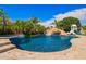Inviting backyard pool area with a rock waterfall feature, slide, and lush landscaping for Gathering fun at 3460 E Lynx Pl, Chandler, AZ 85249