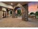 An outdoor space showcasing a stone arch, grilling area, lush greenery, and fire pit by the pool, perfect for entertaining at 3523 E Presidio Cir, Mesa, AZ 85213