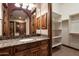 Bathroom with granite counters, wood cabinets, vanity mirror, and walk-in closet at 3523 E Presidio Cir, Mesa, AZ 85213