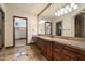Elegant bathroom with granite countertops, dark wood cabinets, a large mirror, and an adjacent walk-in closet at 3523 E Presidio Cir, Mesa, AZ 85213