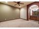 Bedroom with a ceiling fan, neutral walls, and archway leading to the bathroom at 3523 E Presidio Cir, Mesa, AZ 85213