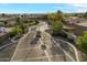 A grand community entrance with secure gate access surrounded by lush landscaping in an aerial shot at 3523 E Presidio Cir, Mesa, AZ 85213