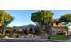 Inviting front exterior showcasing a beautifully landscaped yard and a charming water feature with mature trees at 3523 E Presidio Cir, Mesa, AZ 85213