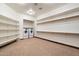 Bright laundry room offering built-in shelving, front-loading washer and dryer, and neutral carpeting at 3523 E Presidio Cir, Mesa, AZ 85213