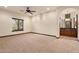 Living room with neutral carpet, ceiling fan, picture window, and built-in cabinetry with granite counters at 3523 E Presidio Cir, Mesa, AZ 85213
